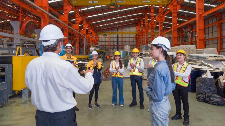 Warehouse meeting, people with hard hats. Industrial teamwork. 